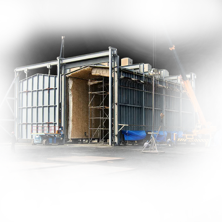 Two large field grey PWHT furnaces with construction workers surrounding it